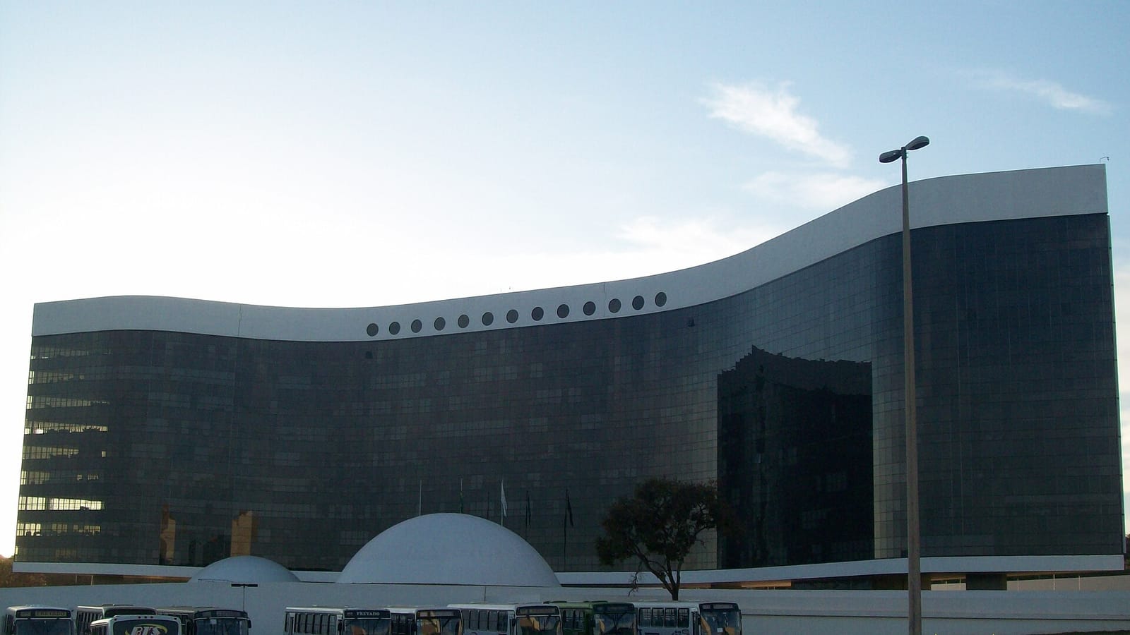 Urna eletrônica brasileira ao lado de documentos oficiais, representando a disputa eleitoral e a tramitação de informações no Tribunal Superior Eleitoral.
