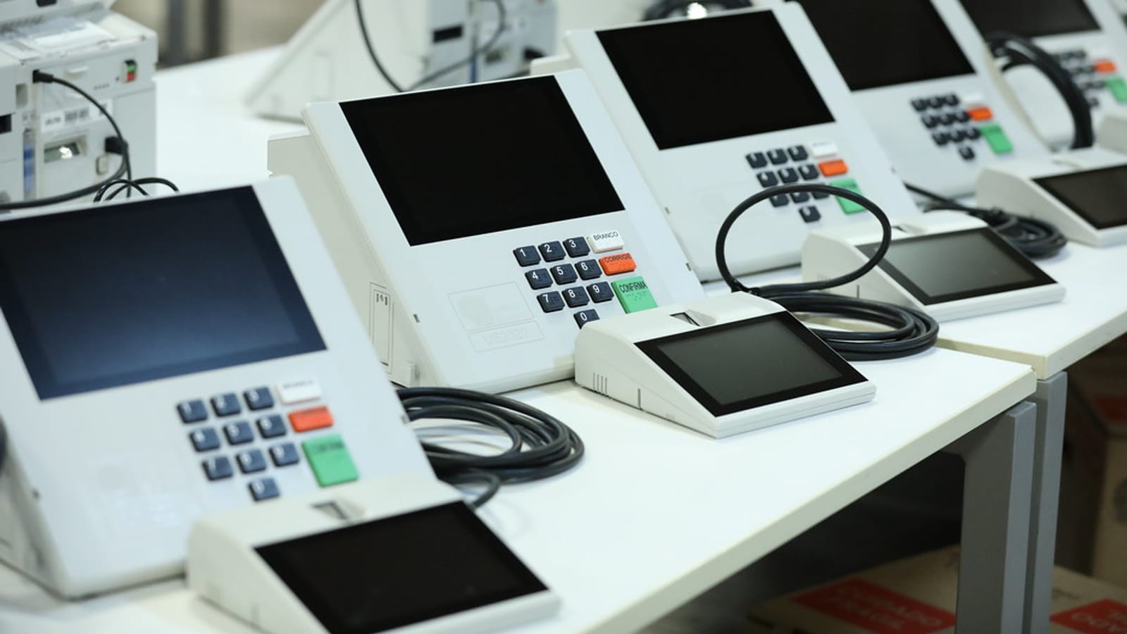 Urna eletrônica utilizada em uma eleição, com eleitor em processo de votação.