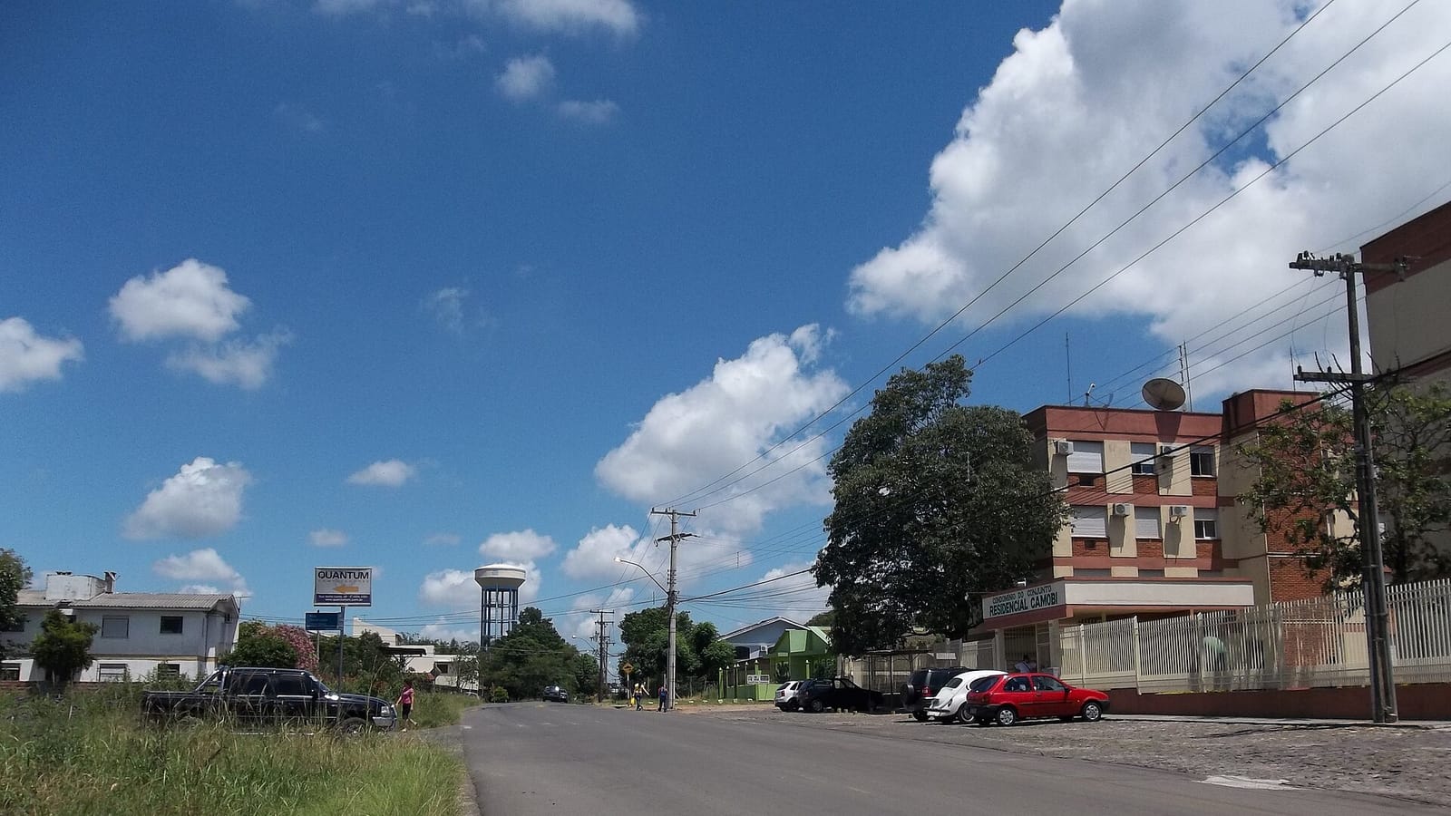 Viatura policial em uma ocorrência de segurança pública, com área urbana ao fundo, sem identificação de pessoas.