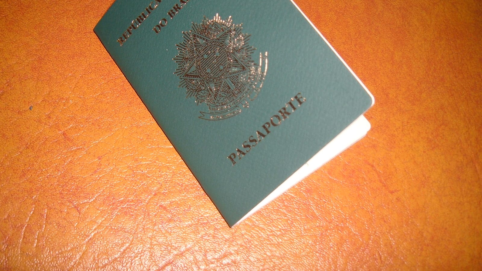 Imagem ilustrativa de um passaporte brasileiro sobre uma superfície, representando a discussão sobre a saída de um senador do país.